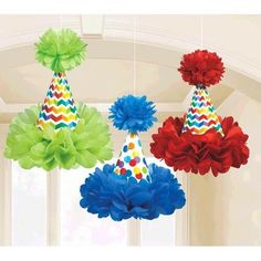 three party hats hanging from the ceiling with tissue pom poms on it's head