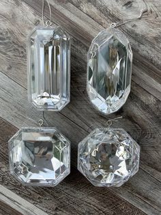 three clear glass ornaments hanging on a wooden wall