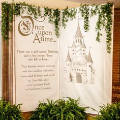 an open book on display in front of some plants and ivy growing up the wall