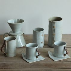 a group of coffee cups and saucers sitting on top of a wooden table