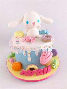 a cake decorated with donuts, cupcakes and an adorable bunny sitting on top