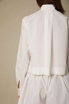 Beautifully tailored from Italian organic cotton poplin, the Cole shirt in crisp white features a waist length silhouette, a high-low hem, a back panel pleat and matching covered buttons at placket and cuffs. The slightly loose fit lends an effortless quality. Fit: Bianca, our model is 5.8” or 1.77 m tall and wears size 1. Content: 100% organic cotton poplin. Care instructions: - For easy care, professional wash and fold is recommended. - Machine wash on the delicate cycle with like colors. - Tu Fitted White Poplin Top, White Poplin Tops For Daywear, White Poplin Shirt For Daywear, Wash And Fold, Cropped Shirt, Waist Length, Crop Shirt, High Low Hem, Covered Buttons