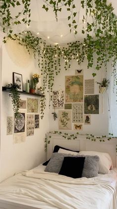 an unmade bed with lots of plants hanging from it's headboard and pillows