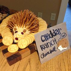 a hedgehog made out of crackers sitting on a table next to a sign that says cheddar ranch