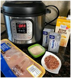 an instant pot with meat, rice and other ingredients in front of it