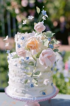 a wedding cake with white frosting and pink flowers