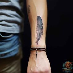 a person with a feather tattoo on their wrist