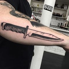 a man with a knife tattoo on his arm