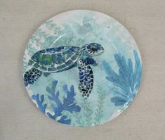 a blue and white plate with a sea turtle on it's side sitting on a table