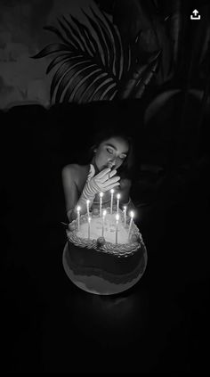 a woman blowing out candles on a cake with her face in the middle of it