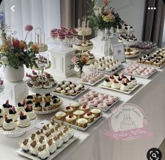 a table topped with lots of cakes and cupcakes