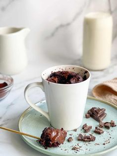 there is a cup of chocolate cake on the plate