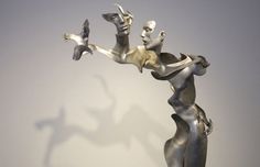 a sculpture is shown in the shape of a woman holding a bird on her arm