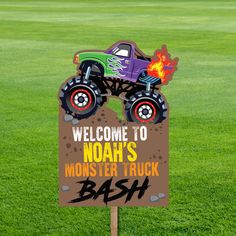 a yard sign with a monster truck on it in front of some grass and fire