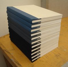 a stack of books sitting on top of a wooden table