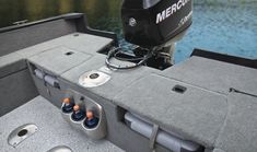 the inside of a gray boat with four bottles in it's center console area