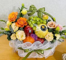 an arrangement of fruit and flowers on a table