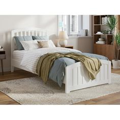 a white bed sitting on top of a wooden floor