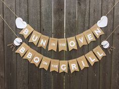 bunting in the oven on the grill sign hanging from a wooden fence with paper decorations