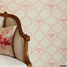 a chair with a pillow on top of it next to a wallpapered background