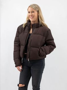 On a cold winter day, there's nothing better than snuggling up in a cozy jacket. But just because you're bundled up doesn't mean you have to sacrifice style. This dark brown cropped puffer jacket perfectly combines comfort and fashion. The quilted construction and standing collar will keep you warm, and because it's slightly cropped, it's the perfect piece to pair with leggings or jeans. So don't let the cold weather keep you from looking your best. Add this jacket to your outerwear collection a Brown Winter Puffer Jacket For Cold Weather, Brown Long Sleeve Puffer Jacket For Cold Weather, Brown Puffer Jacket With Padded Collar For Fall, Casual Brown Quilted Jacket For Winter, Brown Puffer Jacket For Cold Weather, Casual Brown Quilted Winter Jacket, Trendy Brown Puffer Outerwear, Quilted Cropped Jacket For Fall, Trendy Brown Puffer Jacket For Fall