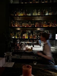 a woman is behind the bar at a restaurant