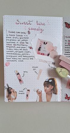 an open notebook with pink and white items on it, including lipstick, eyeliners, hair clips, and sunglasses