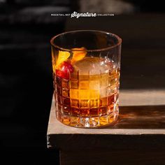 a glass filled with liquid sitting on top of a wooden table