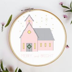 a cross stitch pattern with a pink church on it's side and the words merry and bright written in white