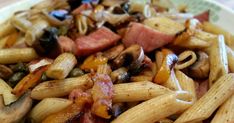 pasta with ham, mushrooms and olives in a bowl