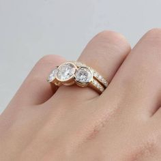 a woman's hand with three diamond rings on it