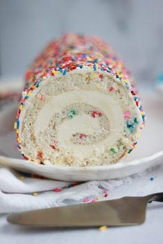 a cake roll with sprinkles is on a plate