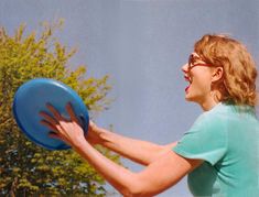 a woman holding a blue frisbee in her right hand