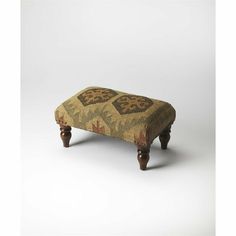 a foot stool made out of wood and fabric with an intricate design on the top