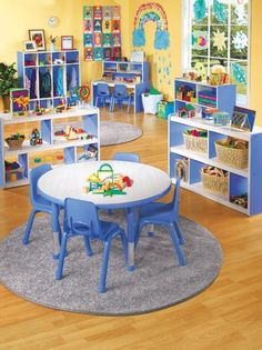 a child's playroom with blue chairs and tables