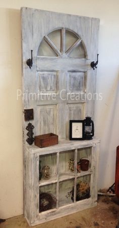 an old wooden cabinet with glass doors on it's sides and shelves in front of the door