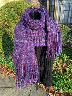 "This is a 100% handmade knitted shawl with fringe and colored accents. It is super soft and its long length allows it to be worn in various ways. The entire length of the shawl is lined with colored, hair-like strands that flow in the breeze. Not only will this designer shawl keep you very warm, but it will be an eye-catching feature of any outfit. Measurements: 80\" x 18\" Dry clean only. Fold gently, do not hang. As these items are handmade, all measurements are approximate and there may be subtle variation. Length measurements include the fringe and tassels. Please note: the colors of some pictures may vary slightly on different monitors. Most pictures were taken in sunlight to best show the palate of colors in the context in which they are most commonly worn. Accordingly, some colors Purple Knitted Scarf, Purple Chiffon Scarf Long, Designer Shawl, One Size Purple Bohemian Scarf, Knit Purse, Hand Knit Shawl, Gold Brocade, Handwoven Multicolor One-size Shawl, Purple Bohemian Scarf, One Size