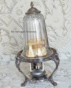 an old fashioned glass and metal lamp with gold decorations on the top, sitting on a table