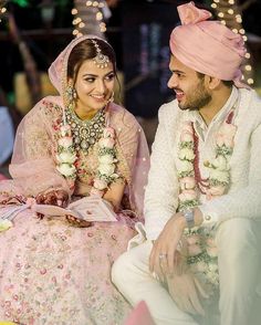 a man and woman sitting next to each other in front of a building with lights