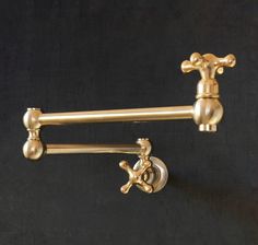 two golden faucets on a black wall