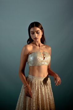 Nude cream lehenga set features gota work highlighted with sequin & cutdana hand work. The halter blouse & dupatta are intricately hand embroidered using silver sequin, gota & cutdana Glamorous Saree Set With Gota Work, Glamorous Festive Lehenga With Cutdana Details, Glamorous Lehenga With Cutdana For Festive Occasions, Glamorous Festive Lehenga With Cutdana, Glamorous Party Choli With Gota Work, Glamorous Gota Work Lehenga For Diwali, Glamorous Party Sharara With Gota Work, Glamorous Cutdana Choli For Diwali, Glamorous Cutdana Lehenga For Festive Occasions