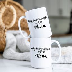 two white coffee mugs sitting on top of a table next to each other with the words, my favorite people call me mama