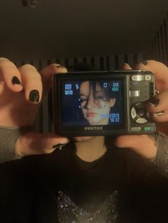 a person holding up a camera to take a selfie with their face in the mirror