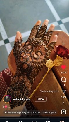 a woman's hand with henna on it and a flower in the middle