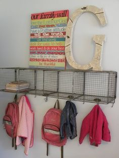 there is a metal rack with backpacks on it and coat hooks hanging from the wall