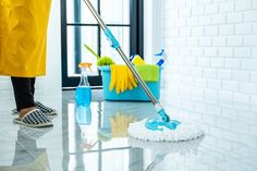 a person cleaning the floor with a mop and sponges in front of them