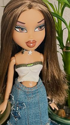 a close up of a doll with long hair wearing a white top and blue jeans