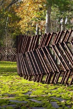 a row of wooden slats sitting in the grass