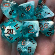 blue and white marble dice with numbers on them in the palm of someone's hand