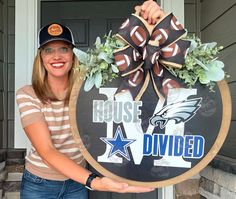 a woman holding up a sign that says house divided with an eagle and football on it